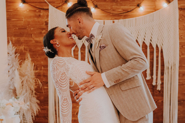 Braut und Bräutigam küssen sich nach dem Ja-Wort während der Hochzeit in der Tenne